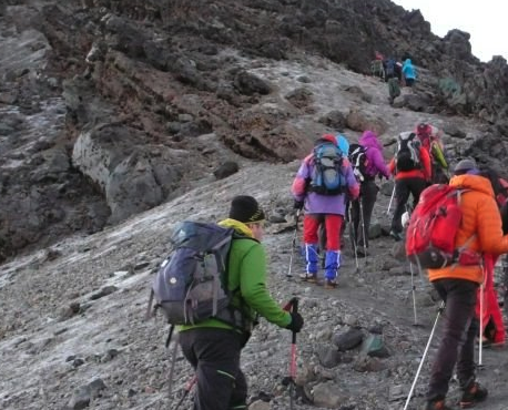 Climbers trekking on Mount Meru rocky terrain